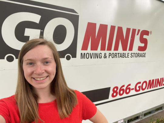 woman standing in front of a go minis van